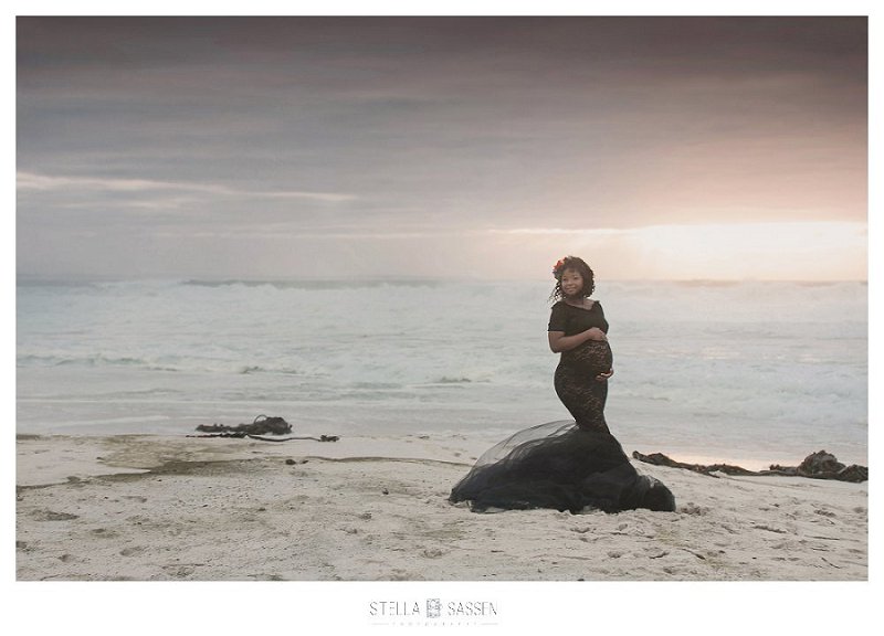 Maternity photo of pregnant woman at the beach at sunset