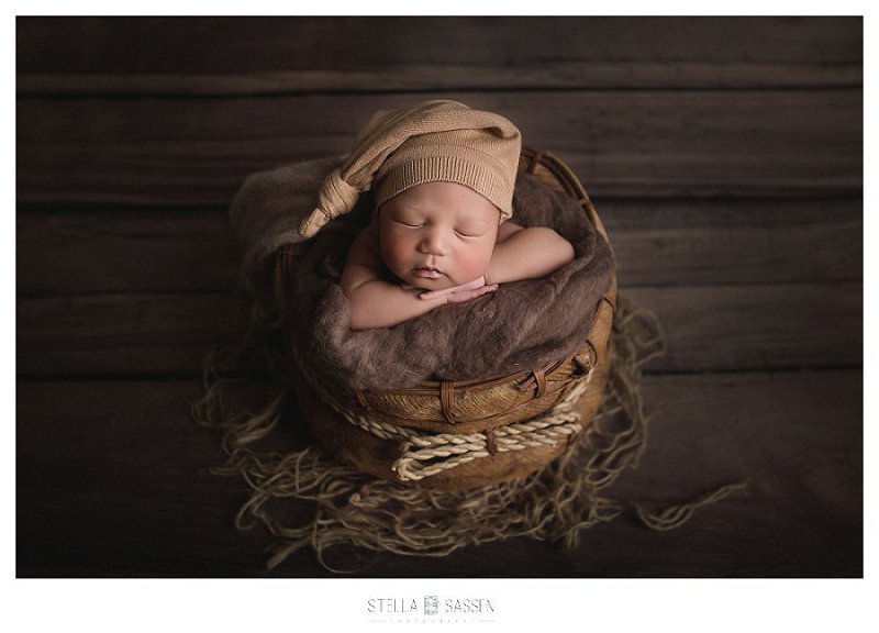 Newborn baby in wooden prop for shoot
