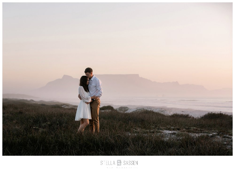 Roamatic photo of couple in front of Table Mountain at sunset