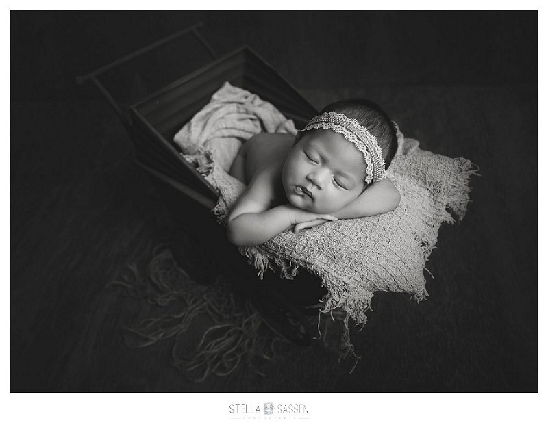 Newborn baby girl in prop wagon studio shoot