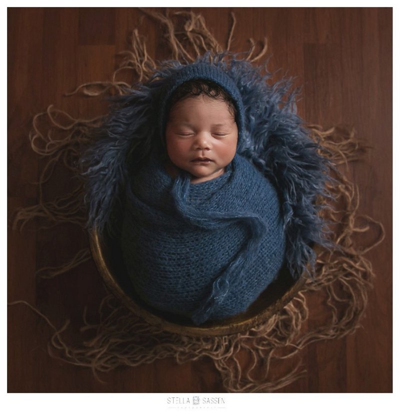 newborn baby wrapped in basket for photo shoot