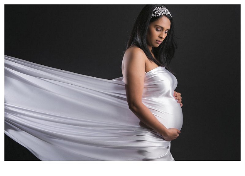 maternity photograph of woman in white material draped