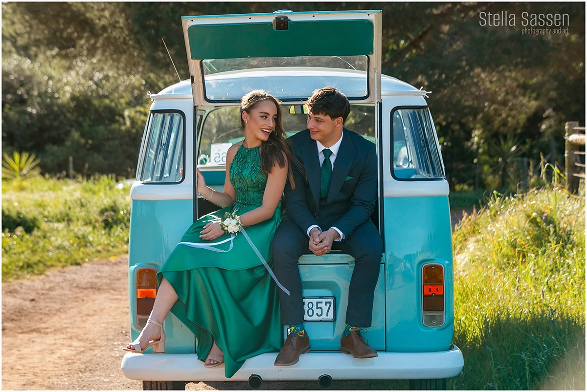 Young couple dressed for their matric farewell posing in an old Volkswagen combi